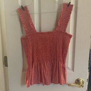 55% Linen 45% rayon. Orange/red top with peplum detail.